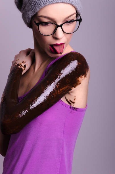 linda namorada hipster ou esposa suja com chocolate no estúdio - sticking out tongue animal tongue teenage girls licking - fotografias e filmes do acervo