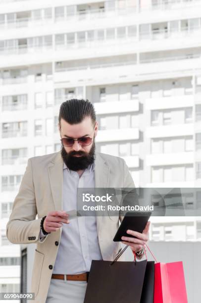 Businessman In A Suit With A Long Beard Holding Shopping Bags And Credit Card Stock Photo - Download Image Now