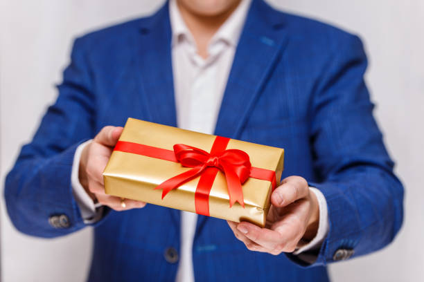 istock Male hands holding a gift box with ribbon. 659055936