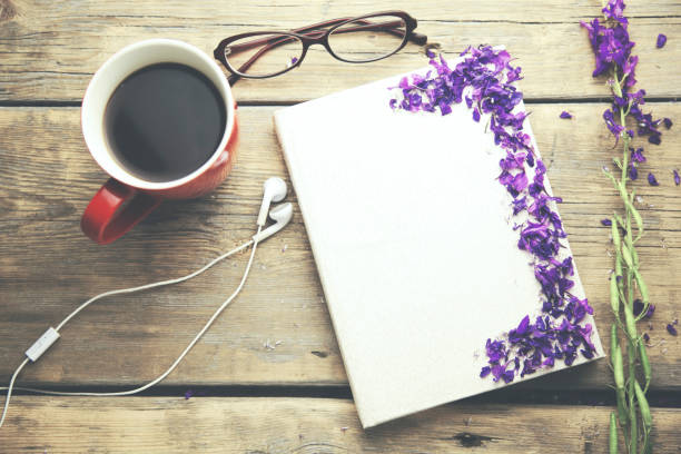 istock flowers and glasses on notebook and cup of coffee and headset on table 659082430