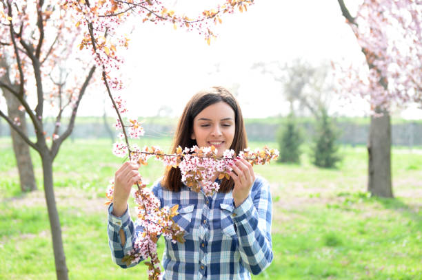 istock Outdoors portrait of beautiful girl standing between cherry tree in full bloom in spring 659085330