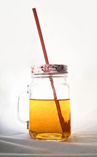 Yellow drink in a transparent glass mug