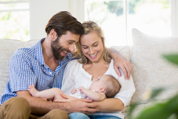 istock Parents sitting on sofa with their child 659095542