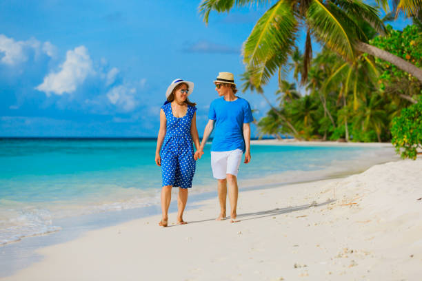 istock happy loving couple walking on summer beach 659112522