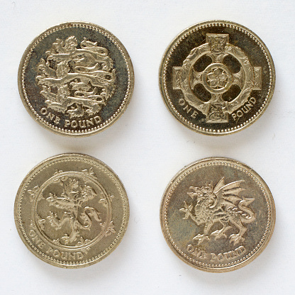 Four British pound coin designs each showing a regional emblem: England, three lions passant; Northern Ireland, a Celtic cross; Scotland, lion rampant; and Wales, a dragon guardant. Coins range in date from 1994 to 2002. This round coin design is being replaced today, 28th March 2017.