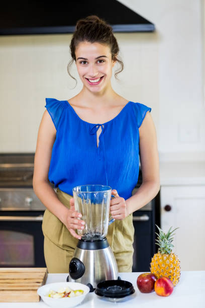 istock Happy young woman standing with mixer 659141694