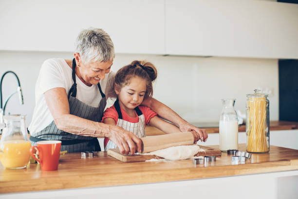 istock Small girl learning to roll cookie dough 659151870