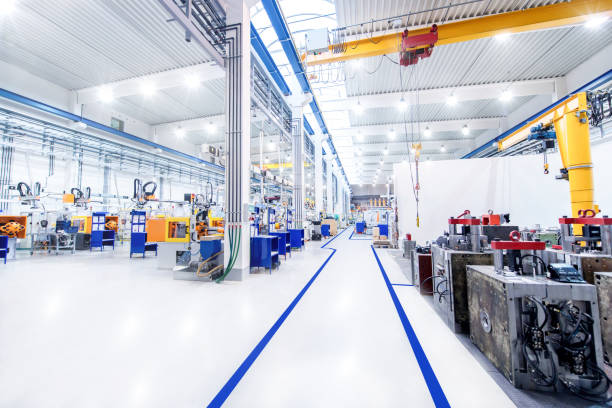 Modern factory & aisle Horizontal image of huge new modern factory with robots and machines producing industrial plastic pieces and equipment. Wide angle view of futuristic machines and long aisle. metal industry photos stock pictures, royalty-free photos & images