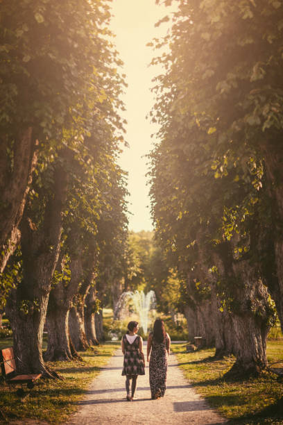 Two middle aged women out walking on a park path in summer.