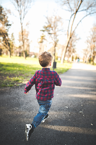 Small boy running in the park on a sunny day
