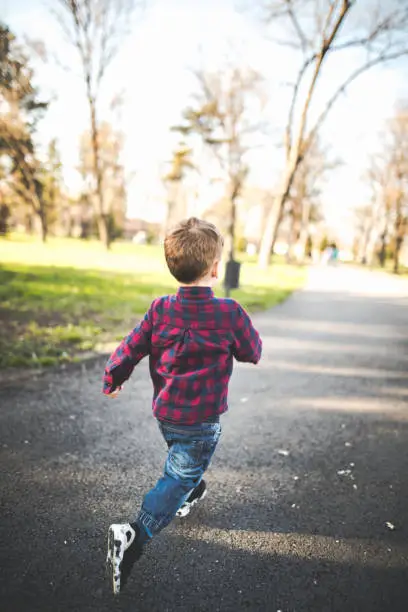 Small boy running in the park on a sunny day