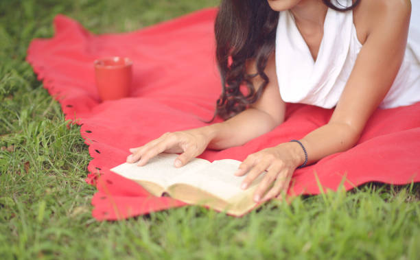 istock Young beautiful woman reading book outdoors in park on a sunny day 659183104