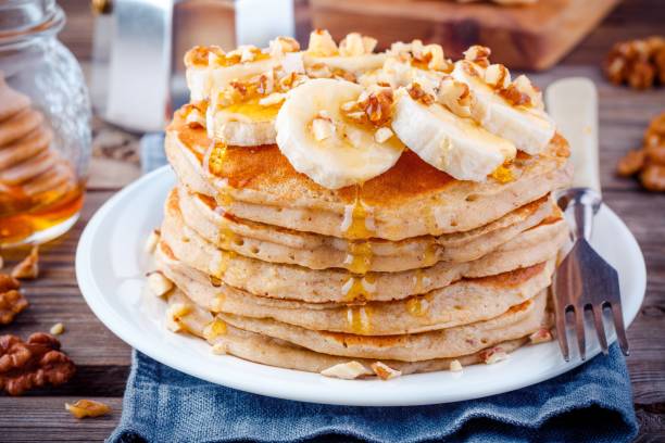 Oat pancakes with banana, walnuts and honey Breakfast oatmeal pancakes with banana, walnuts and honey pancake stock pictures, royalty-free photos & images