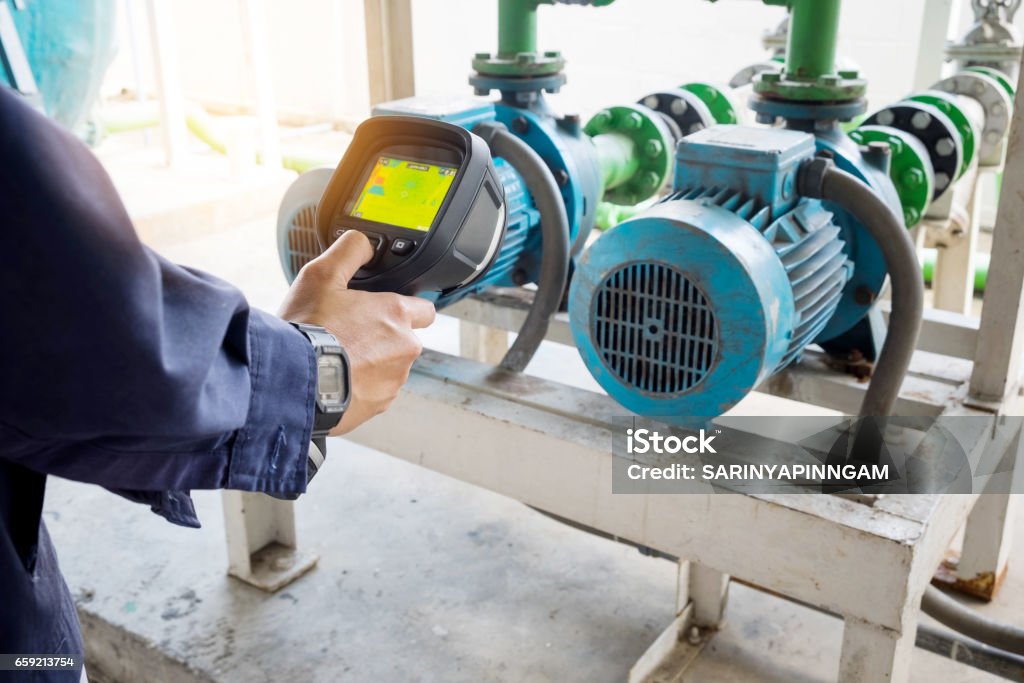 technician use thermal imaging camera to check temperature in factory Thermal Image Stock Photo