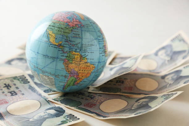 istock Tiny Earth globe over the surface covered with the multiple bank note bills, shallow depth of field composition 659221254