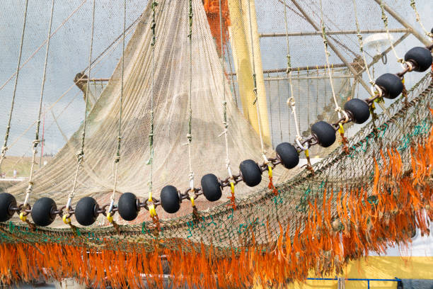 Boom with fishing nets on commercial fishing boat trawler in harbour of Texel, Netherlands