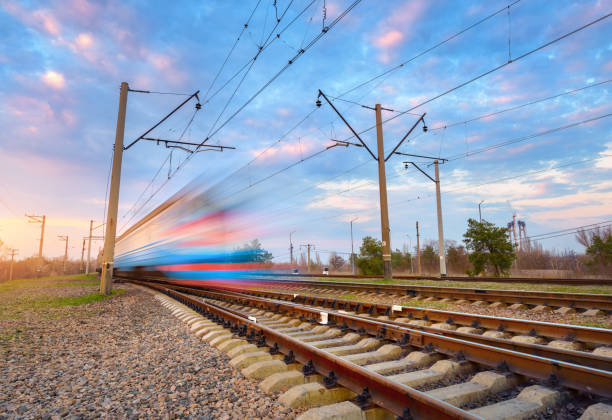 istock High speed blue passenger train in motion on railroad at sunset. Blurred commuter train. Railway station against colorful sky. Railroad travel, railway tourism. Rural industrial landscape. Concept 659227270