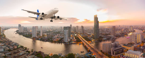 Airplane take off over the panorama city at sunset