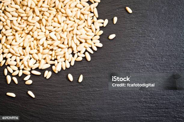 Pine Nuts On Dark Slate Table Stock Photo - Download Image Now - Pine Nut, Peeled, Abundance