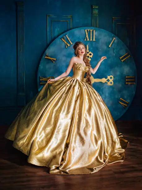 Beautiful woman in a golden ball gown in the great blue interior