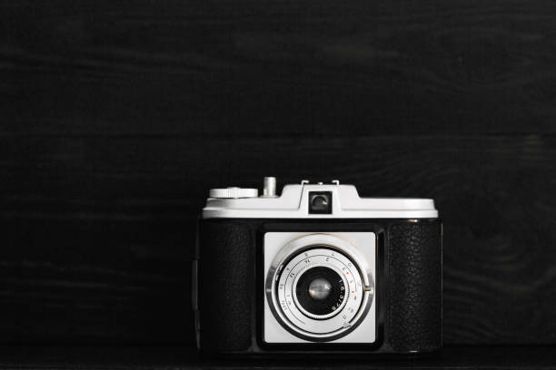 istock Retro photo camera on a black wooden background 659284264