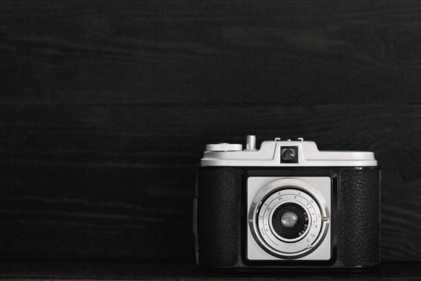 istock Retro photo camera on a black wooden background 659284294