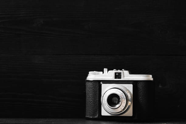 istock Retro photo camera on a black wooden background 659284560