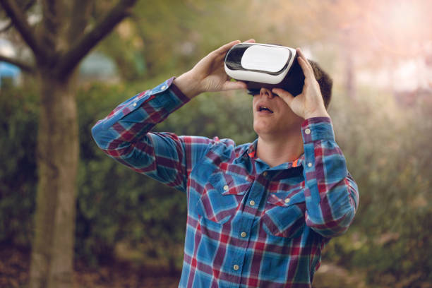 istock man wearing virtual reality goggles outside in nature 659307082