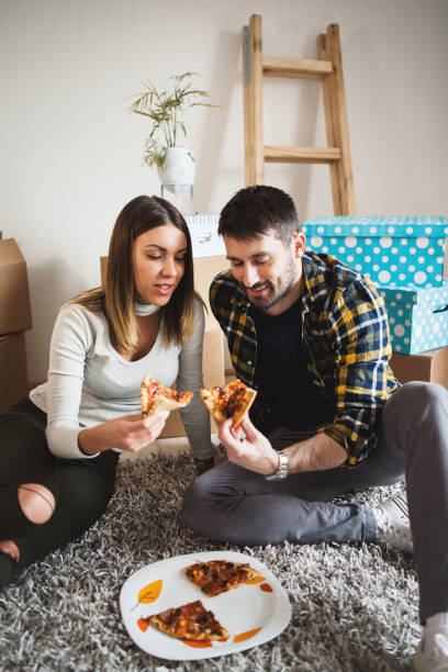 istock Couple Moving to new house eating pizza 659336574