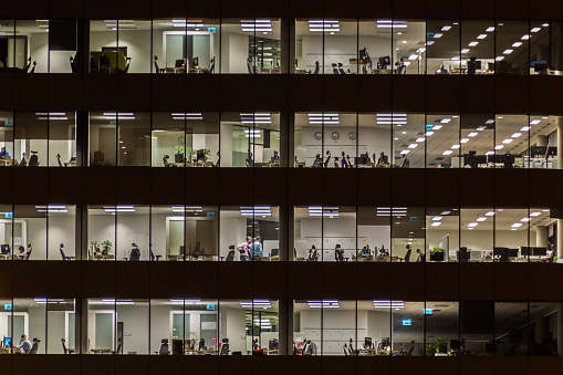 Office windows at night, people at work.