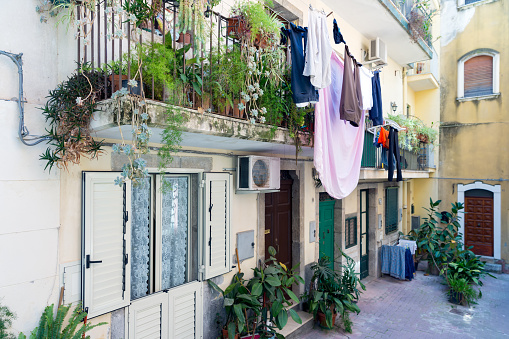 TAORMINA, ITALY - MAY 17, 2016: Courtyard with balcony, plants and laundry in Taormina at Sicilian Island, Italy