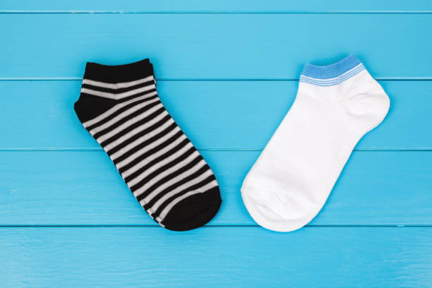 istock Pair of socks laying on a blue background. 659383736