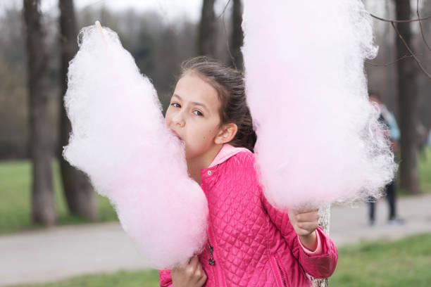 istock Sweet girl with candy floss in the park 659384832