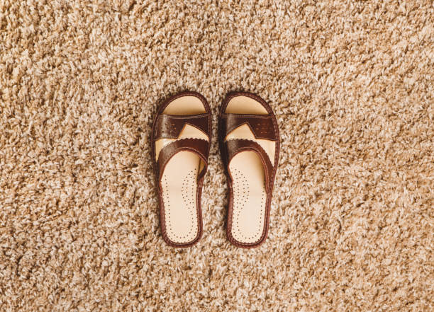 istock Brown slippers on the carpet 659392910