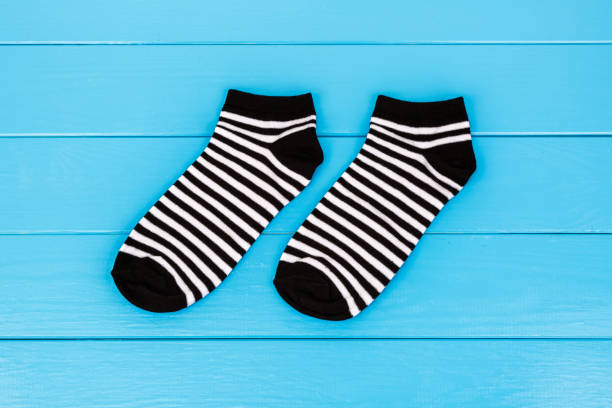 istock Pair of socks laying on a blue wooden background. 659393208