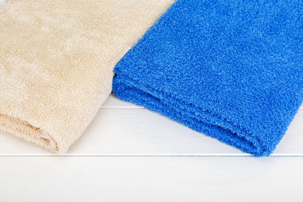 istock Two towels laying on a white wooden background. 659394796