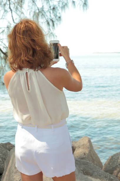 istock Woman on a sea side. Photographing. 659438926
