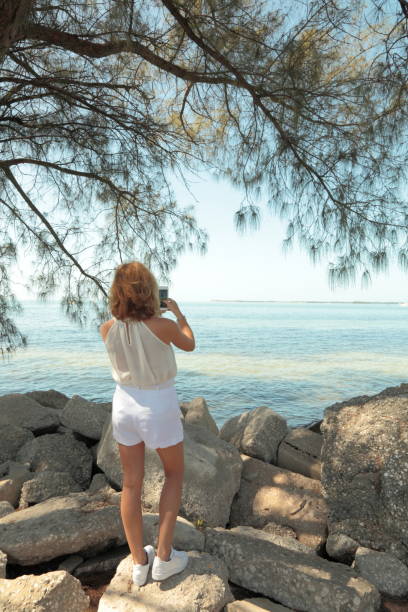 istock Woman on a sea side. Photographing. 659443796