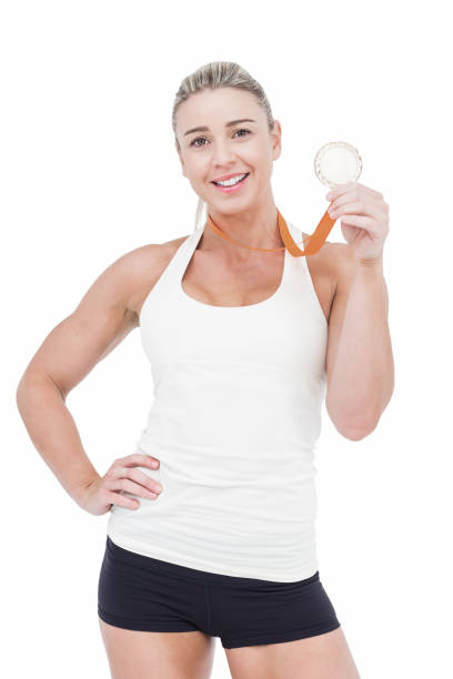 female athlete holding medal - effort gold indoors studio shot imagens e fotografias de stock