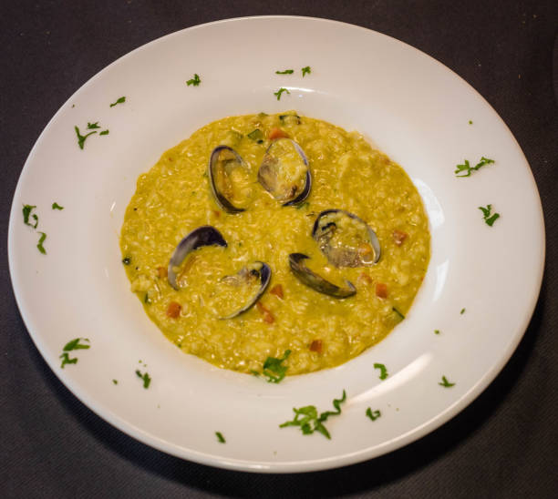 Clam risotto Creamy clam risotto decorated with parsley comida italiana stock pictures, royalty-free photos & images