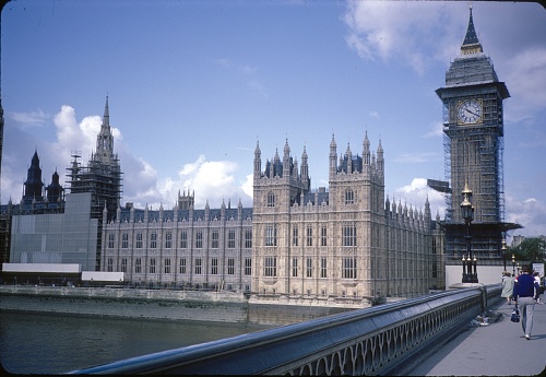 London, England, UK, 1985. Exterior View of Palace of Westminster. The seat of the British Parliament, in which the House of Commons and the House of Lords are housed. Also well recognizable is the most famous tower of Westminser Palace, the so-called Big Ben (officially Great Bell of Westminster). Parts of the building, as well as the tower, are encased in scaffolding. The recording was taken by the Westminster Bridge.