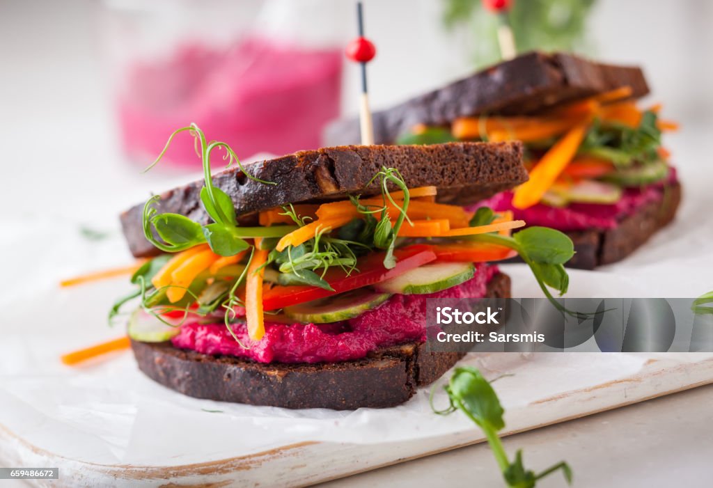 appetizer gluten free vegan sandwiches with beet hummus, raw vegetables and sprouts. soft focus Sandwich Stock Photo