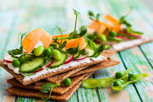 Healthy sandwiches with soft cheese and raw spring vegetables on crisp rye bread
