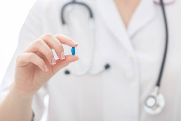 nurse holds blue pill in her hand. - medical sample imagens e fotografias de stock