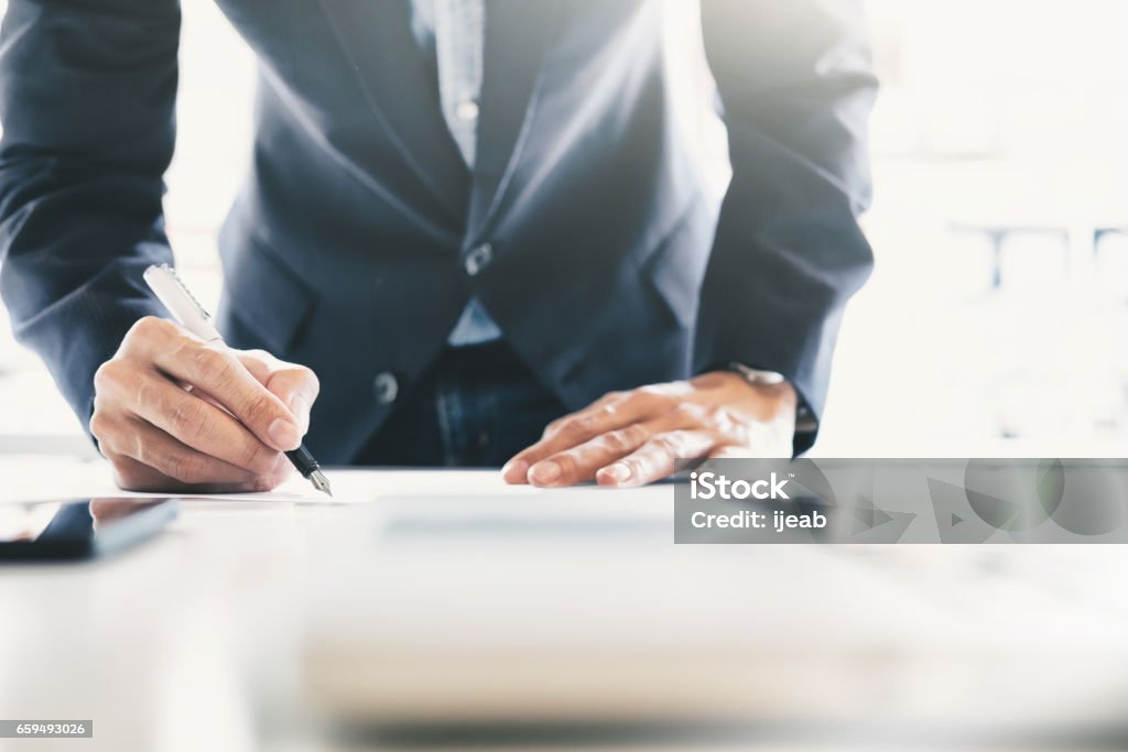 Businessman signing contract making a deal. Close up businessman signing contract making a deal. Signing Stock Photo