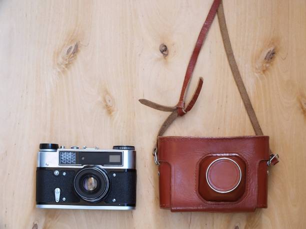 istock Retro photo camera with leather case on wooden background 659507166