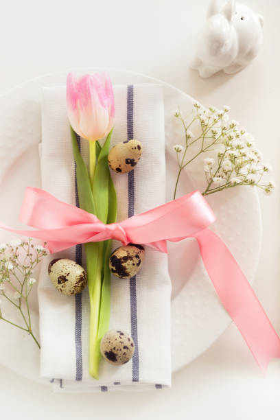 istock Elegance table setting with pink ribbon and tulip on white background. Easter romantic dinner. Top view. 659509410