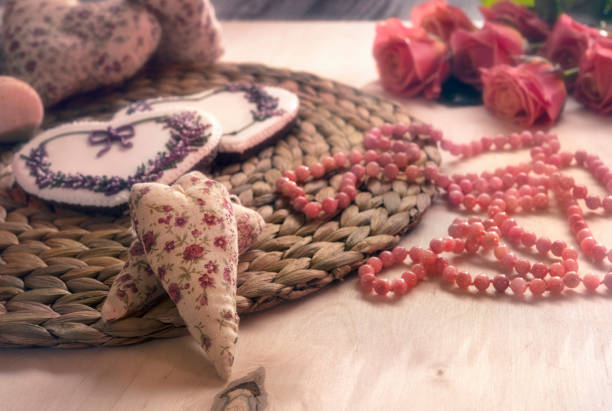 heart pillow, cakes, pink beads and roses on the table