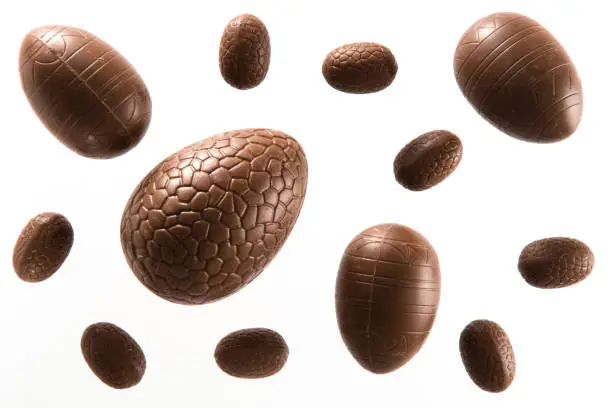 High angle view of a variety of unwrapped Easter chocolate eggs on a white background