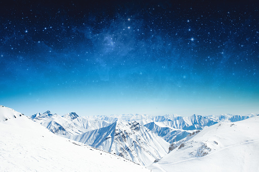 estrellas del cielo de invierno y las montañas cubiertas de nieve photo